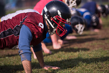 Image showing american football team doing push ups