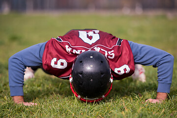 Image showing american football player doing push ups