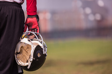 Image showing American football player holding helmet