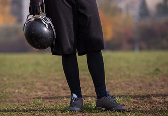 Image showing American football player holding helmet