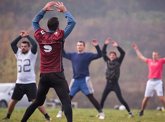 Image showing american football players stretching and warming up