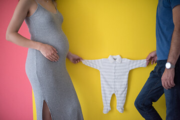 Image showing young couple holding baby bodysuits