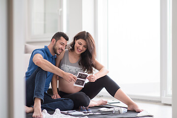 Image showing pregnant couple checking a list of things for their unborn baby