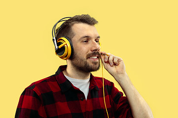 Image showing Half-length close up portrait of young man on yellow background.