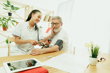 Image showing The visiting nurse taking care of senior man