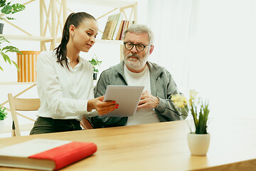 Image showing A daughter or granddaughter spends time with the grandfather