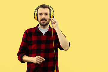 Image showing Half-length close up portrait of young man on yellow background.