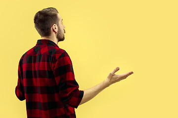 Image showing Half-length close up portrait of young man on yellow background.