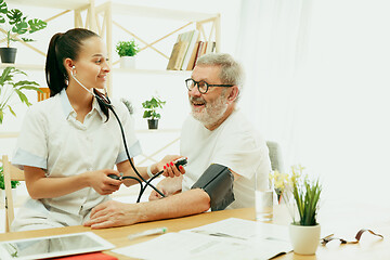 Image showing The visiting nurse taking care of senior man