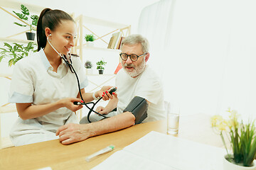 Image showing The visiting nurse taking care of senior man