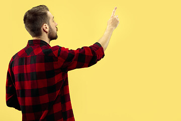 Image showing Half-length close up portrait of young man on yellow background.