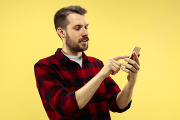 Image showing Half-length close up portrait of young man on yellow background.