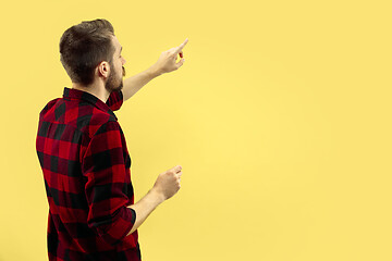 Image showing Half-length close up portrait of young man on yellow background.