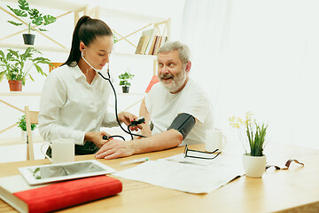 Image showing The visiting nurse taking care of senior man