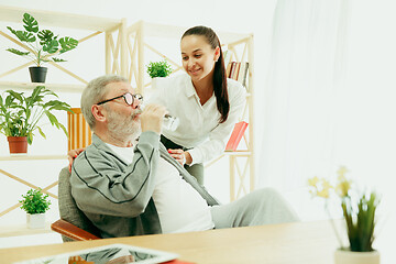 Image showing A daughter or granddaughter spends time with the grandfather