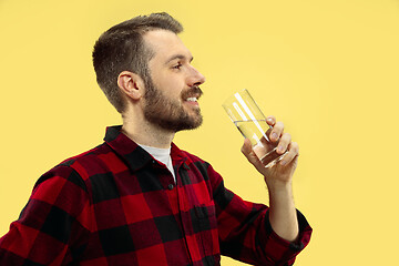 Image showing Half-length close up portrait of young man on yellow background.