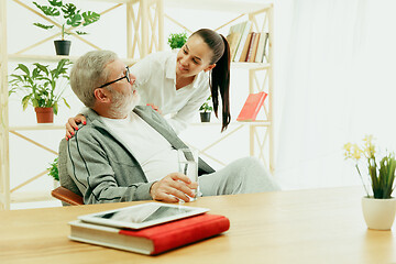 Image showing A daughter or granddaughter spends time with the grandfather