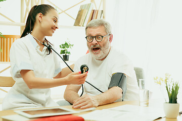 Image showing The visiting nurse taking care of senior man