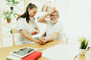 Image showing The visiting nurse taking care of senior man