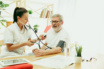 Image showing The visiting nurse taking care of senior man