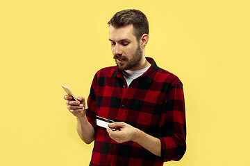 Image showing Half-length close up portrait of young man on yellow background.