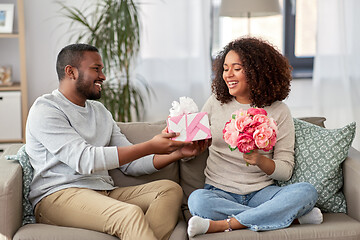 Image showing happy couple with flowers and gift at home