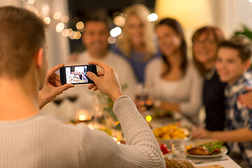 Image showing man taking picture of family at dinner party