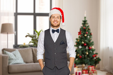 Image showing man in santa hat and suit at home on christmas