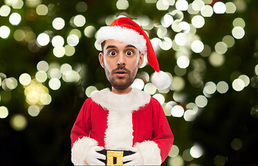 Image showing surprised man in santa costume over christmas tree