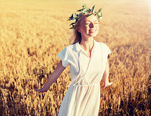 Image showing happy young woman in flower wreath on cereal field