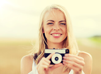 Image showing happy young woman with film camera outdoors