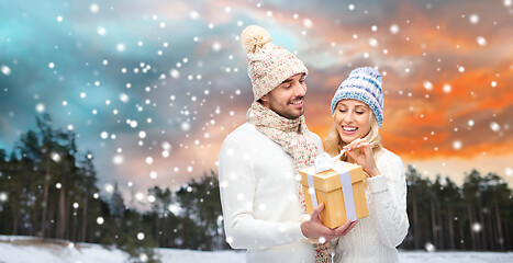 Image showing smiling couple in winter clothes with gift box