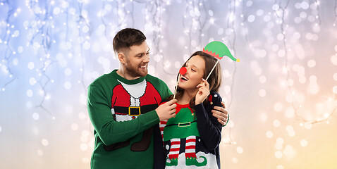 Image showing couple with christmas party props in ugly sweaters