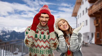 Image showing couple in ugly christmas sweaters over ski resort