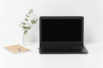 Image showing laptop with black screen on white office table