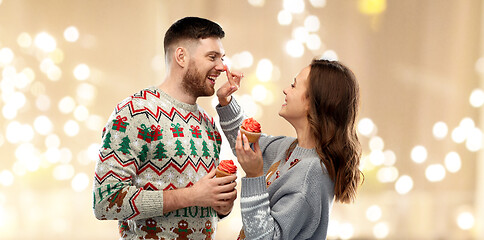 Image showing couple with cupcakes in ugly christmas sweaters