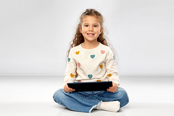 Image showing smiling girl with tablet computer sitting on floor