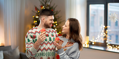 Image showing couple with cupcakes in ugly christmas sweaters