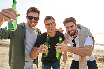 Image showing young men toasting non alcoholic beer on beach