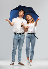 Image showing happy couple in white t-shirts with umbrella