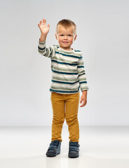 Image showing little boy in striped shirt waving hand