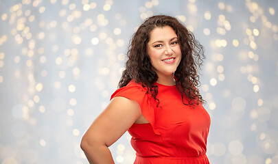 Image showing happy woman in red dress over lights background