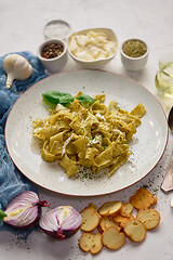 Image showing Cooked homemade pasta with pesto, fresh basil, mozarella cheese and herbs