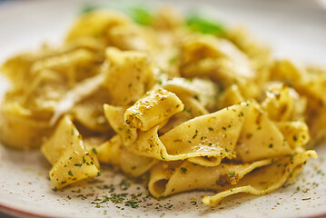 Image showing Close up of fresh cooked tagliatelle pasta with green pesto and herbs