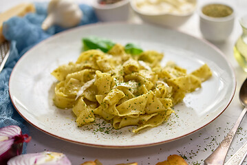 Image showing Cooked homemade pasta with pesto, fresh basil, mozarella cheese and herbs