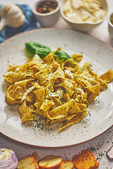 Image showing Cooked homemade pasta with pesto, fresh basil, mozarella cheese and herbs