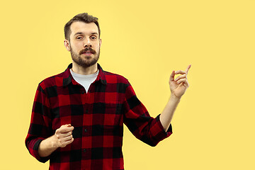 Image showing Half-length close up portrait of young man on yellow background.