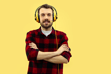 Image showing Half-length close up portrait of young man on yellow background.