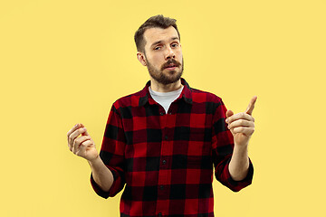 Image showing Half-length close up portrait of young man on yellow background.