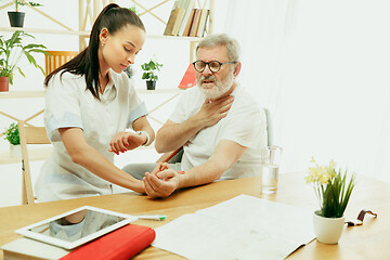 Image showing The visiting nurse taking care of senior man